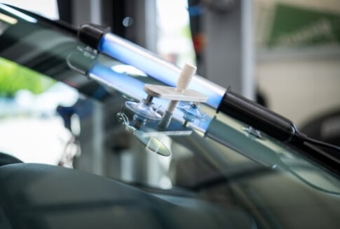 Windshield chip repair equipment mounted on a vehicle's glass