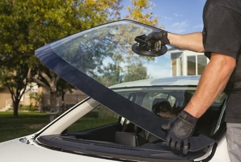 McConnell Auto Glass technician setting a new windshield into a vehicle